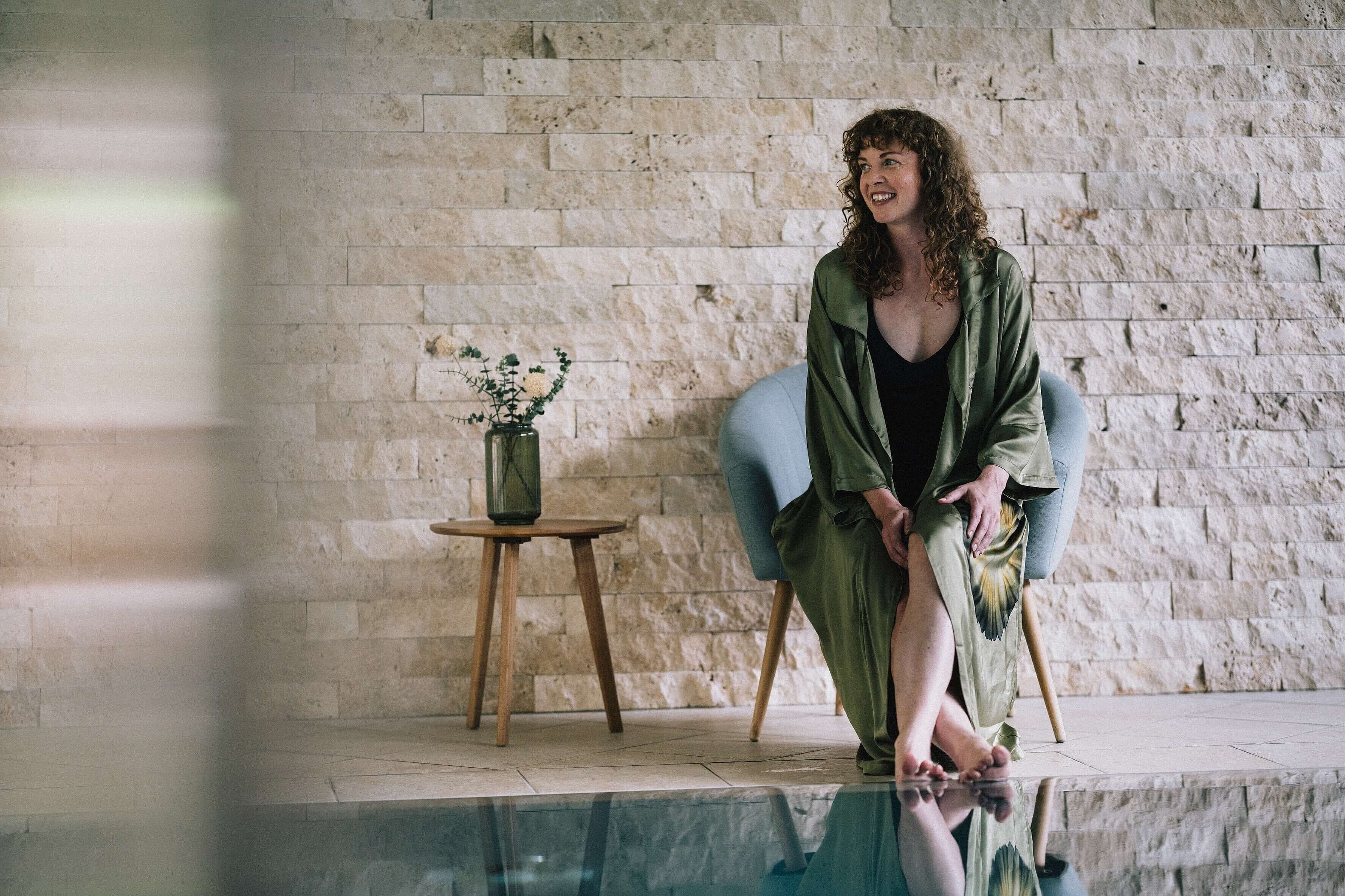 Ankommen und durchatmen bei der Menopause-Woche Frauensache Frau sitzt entspannt im Wellnessbereich am Pool des Vitalhotel Simon