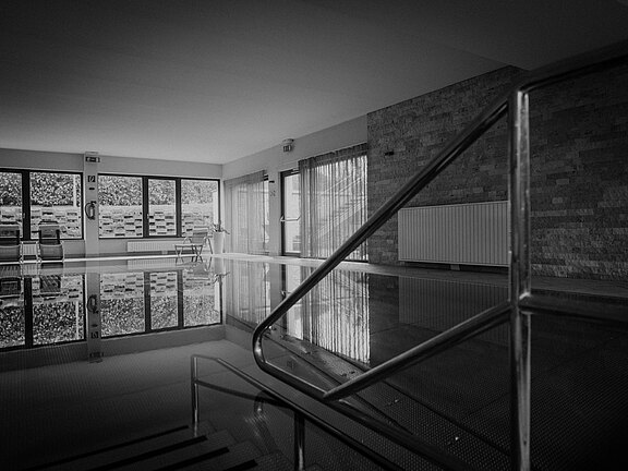 Innenpool im Vitalhotel Simon mit Einstiegstreppe und gemütlichem Ruheraum bei Tageslicht