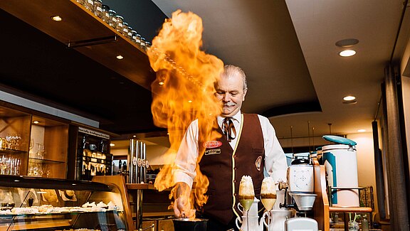 Diplom-Kaffeesommelier Hans Martin Simon beim Kaffeeerlebnis-Vortrag mit flambiertem Kaffee im Hotel-Café Simon in Bad Tatzmannsdorf